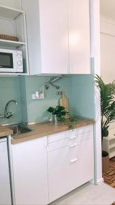 a kitchen with white cabinets and a counter top at Apt 20 min from downtown train in Amadora