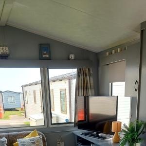 ein Wohnzimmer mit einem großen Fenster und einem TV in der Unterkunft Jock's Place in Whitley Bay