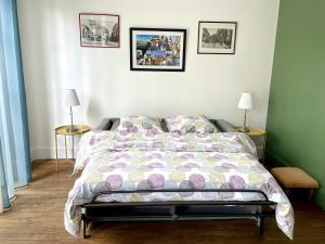 a bedroom with a bed and two tables with lamps at Appartement Le Temple Auxerre Centre Ville in Auxerre