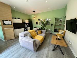 a living room with a couch and a kitchen at La Suite D'Hélène - Appartement T2 50m2 entre Genève et Chamonix - Parking Privé in Scionzier