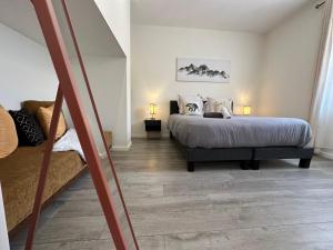 een slaapkamer met een bed en een bank erin bij La Suite D'Hélène - Appartement T2 50m2 entre Genève et Chamonix - Parking Privé in Scionzier