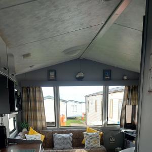 a living room with a couch and a large window at Jock's Place in Whitley Bay