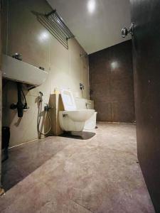 a bathroom with a toilet and a sink at Hotel Nova Vesu in Surat