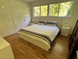 - une chambre avec un grand lit et 2 oreillers dans l'établissement Stunning Modern Beach House with Swimming Pool and Spectacular Sunsets, à Wymbolwood Beach