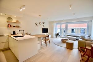 a kitchen and living room with a table and a couch at Appartement 3CH entièrement rénové Knokke - Centre in Knokke-Heist