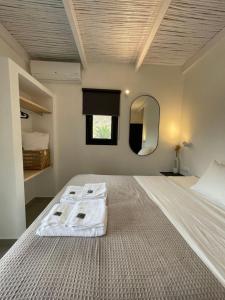 GanemaVie rêvée luxury suites的卧室里有一张带镜子的白色大床