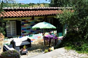 ein Haus mit einem Tisch und einem Sonnenschirm in der Unterkunft Villaggio Naif Girasole in Monterotondo