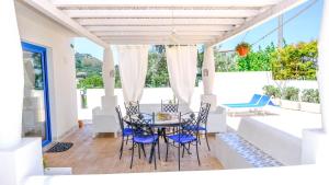 ein Esszimmer mit einem Tisch und Stühlen auf einer Terrasse in der Unterkunft Villa dei Due Ulivi in Capo dʼOrlando