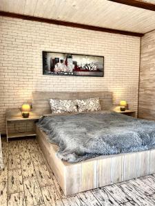 sypialnia z dużym łóżkiem i ceglaną ścianą w obiekcie Edelweiss House w mieście Świtaź