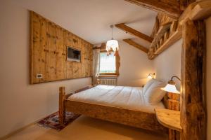 een slaapkamer met een bed in een kamer met houten wanden bij Cesa Anna in Campitello di Fassa