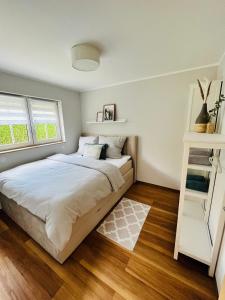 sypialnia z łóżkiem z białymi ścianami i drewnianą podłogą w obiekcie Ferienhaus Lars w mieście Moritzburg