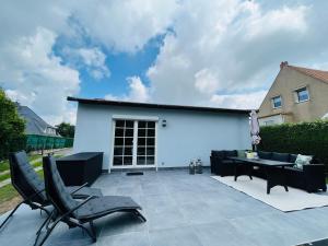 a patio with black chairs and a table at Ferienhaus Lars in Moritzburg