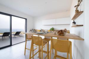 a kitchen with a wooden table and chairs at Villa-soleil-levant vue mer panoramique in Sari Solenzara