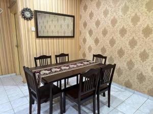 uma sala de jantar com uma mesa e quatro cadeiras em Homestay Jati by NazTi em Seremban