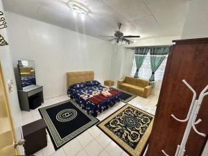 uma sala de estar com uma cama e uma ventoinha de tecto em Homestay Jati by NazTi em Seremban