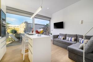 a kitchen and living room with a couch and a table at Michelangelo City Luxury Lodge in Kos Town