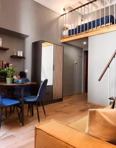 a living room with a dining room table and blue chairs at Duomo Suites Florence in Florence