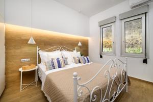 a bedroom with a large bed and two windows at Michelangelo City Luxury Lodge in Kos Town