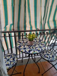 a table and two chairs with a plant on it at Ludovica's House in Giardini Naxos