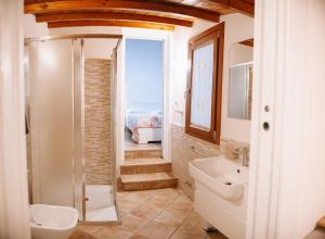 y baño con ducha, aseo y lavamanos. en Magnolia Rooms, en Civitavecchia