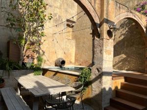 an outdoor patio with a table and a fountain at Can Met Mosso, Casa rural, Piscina Climatitzada Privada in Albóns