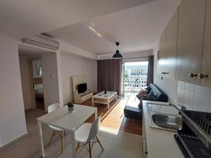 a kitchen and living room with a white table and chairs at Sunny Breeze in Ayia Napa