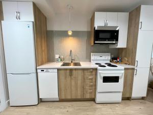 uma cozinha com um frigorífico branco e um lavatório em Tremblant Studio Scandinave by My Tremblant Location em Mont-Tremblant