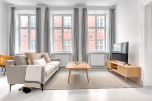a living room with a couch and a table at Cozy Flats in Heart of Copenhagen Near Strøget & Højbro Plads in Copenhagen