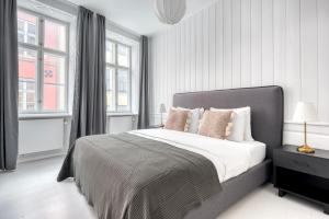 a white bedroom with a large bed with pillows at Cozy Flats in Heart of Copenhagen Near Strøget & Højbro Plads in Copenhagen