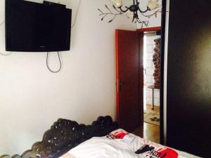 a bedroom with a bed with a television on the wall at Debar Maalo Apartment in Skopje