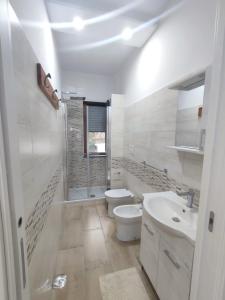 a white bathroom with a toilet and a sink at Bordoriva in Formia