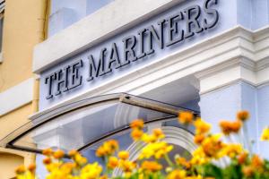 a sign on the side of a building with yellow flowers at The Mariners - Torquay in Torquay