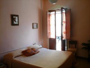 a bedroom with a bed and a large window at L'Antica Locanda in Iglesias