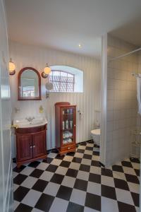 a bathroom with a sink and a toilet and a mirror at Jungshoved Præstegård B&B in Præstø +90 photos