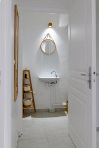 bagno bianco con lavandino e specchio di MadouBamboo a Ducos