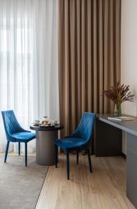 2 blaue Stühle und ein Tisch in einem Zimmer in der Unterkunft Villa Boutique Hotel in Mukatschewo