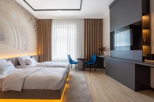 een hotelkamer met een bed en een televisie bij Villa Boutique Hotel in Mukacheve