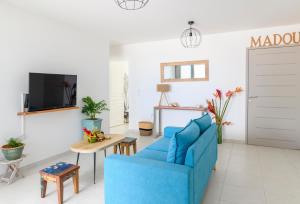 sala de estar con sofá azul y TV en MadouBamboo en Ducos