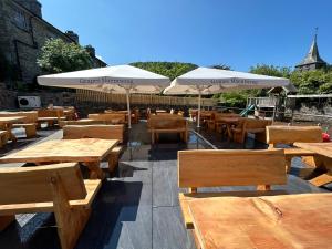 een rij tafels en banken met parasols bij Grapes Hotel, Bar & Restaurant Snowdonia Nr Zip World in Blaenau-Ffestiniog