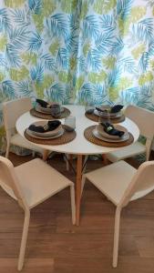 einen weißen Tisch mit zwei Stühlen und Hüten darauf in der Unterkunft Apartamento Centroplaya in Bueu