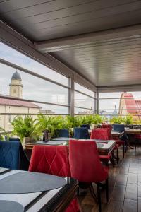 a restaurant with tables and chairs and a large window at Villa Boutique Hotel in Mukacheve