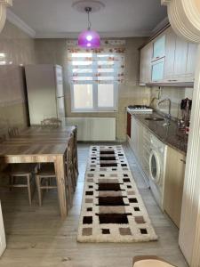 a kitchen with a table and a kitchen rug at Kanarya Apart in Trabzon