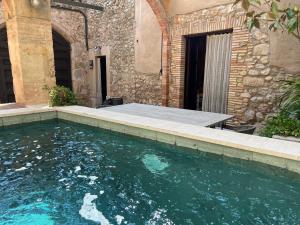 una piscina frente a un edificio en Can Met Mosso, Casa rural, Piscina Climatitzada Privada, en Albóns