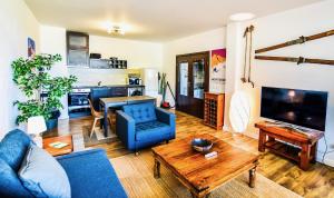 - un salon avec un canapé bleu et une table dans l'établissement Bansko Royal Towers Apartments - Gondola View, à Bansko