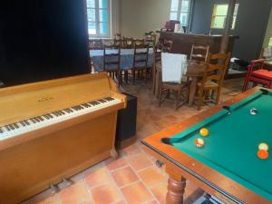 een kamer met een piano en een pooltafel bij Le Rockastel in Le Caylar