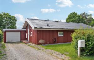 Dronningmølle的住宿－Cozy Home In Dronningmlle With Wifi，一座红色的房子,设有车库和碎石车道