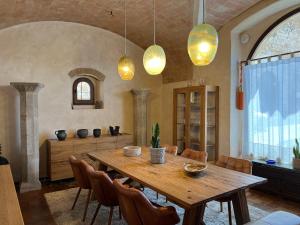 a dining room with a wooden table and chairs at Can Met Mosso, Casa rural, Piscina Climatitzada Privada in Albóns