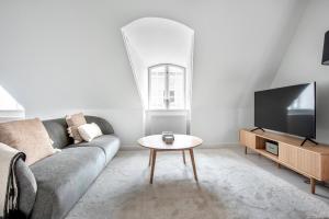 a living room with a couch and a table at Cozy Flats in Heart of Copenhagen Near Strøget & Højbro Plads in Copenhagen