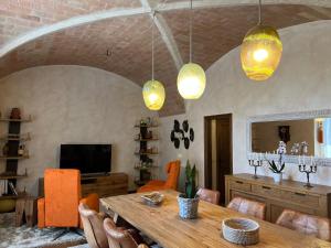 comedor con mesa, sillas y luces en Can Met Mosso, Casa rural, Piscina Climatitzada Privada, en Albóns