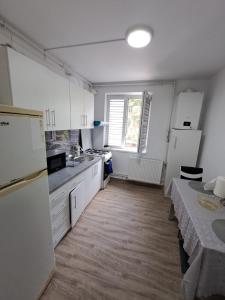 a kitchen with white cabinets and a counter top at Apartament 2 camere in Zalău